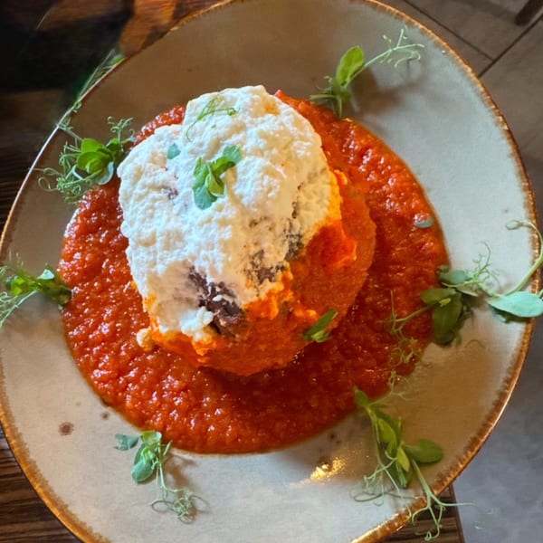 Flavio Restaurant DC's Italian dish with a large dollop of ricotta cheese on a bed of red sauce.
